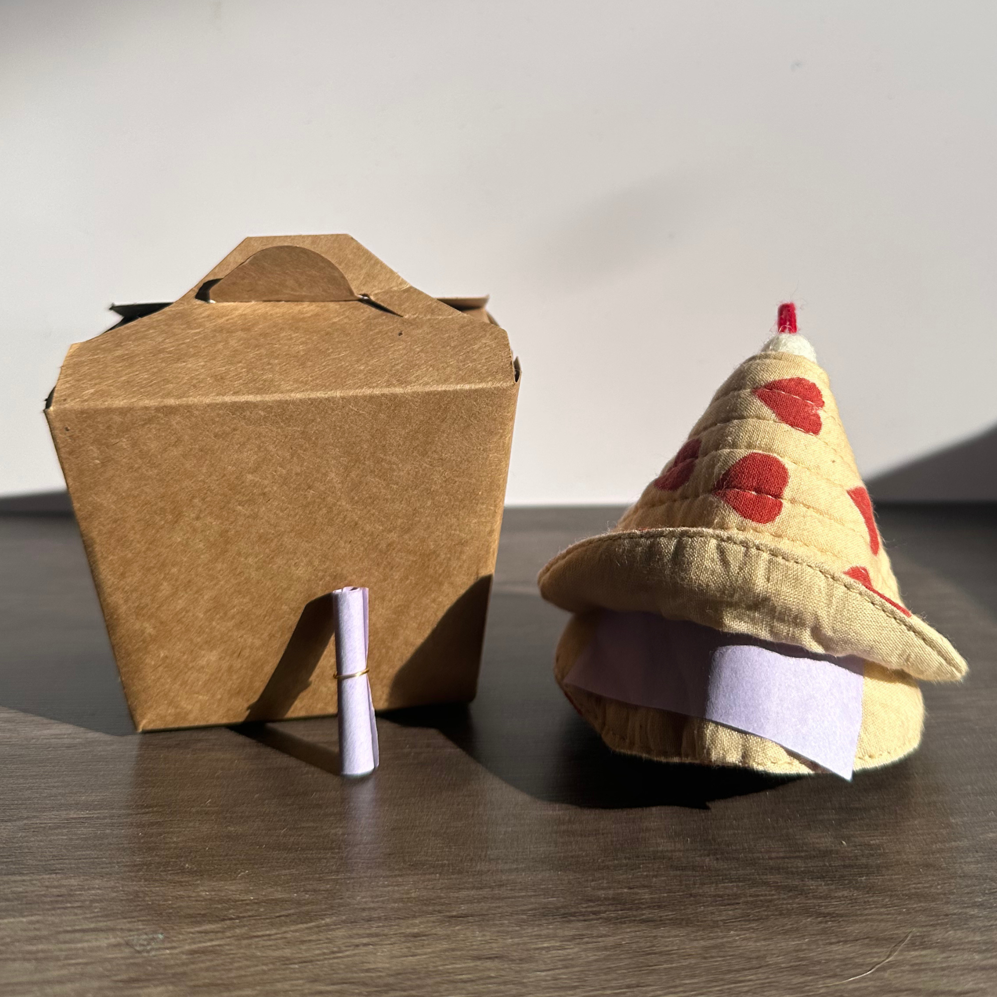 Cardboard box with a small cone-shaped object on a wooden surface